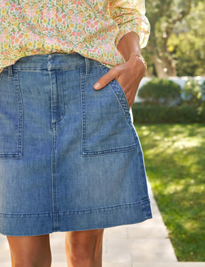 The FRANK & EILEEN Jameson Utility Skirt in Italian Dream Light Denim 1968 Wash is a blue mini skirt with utility pockets, belt loops, and a front zipper closure, shown against a white background.