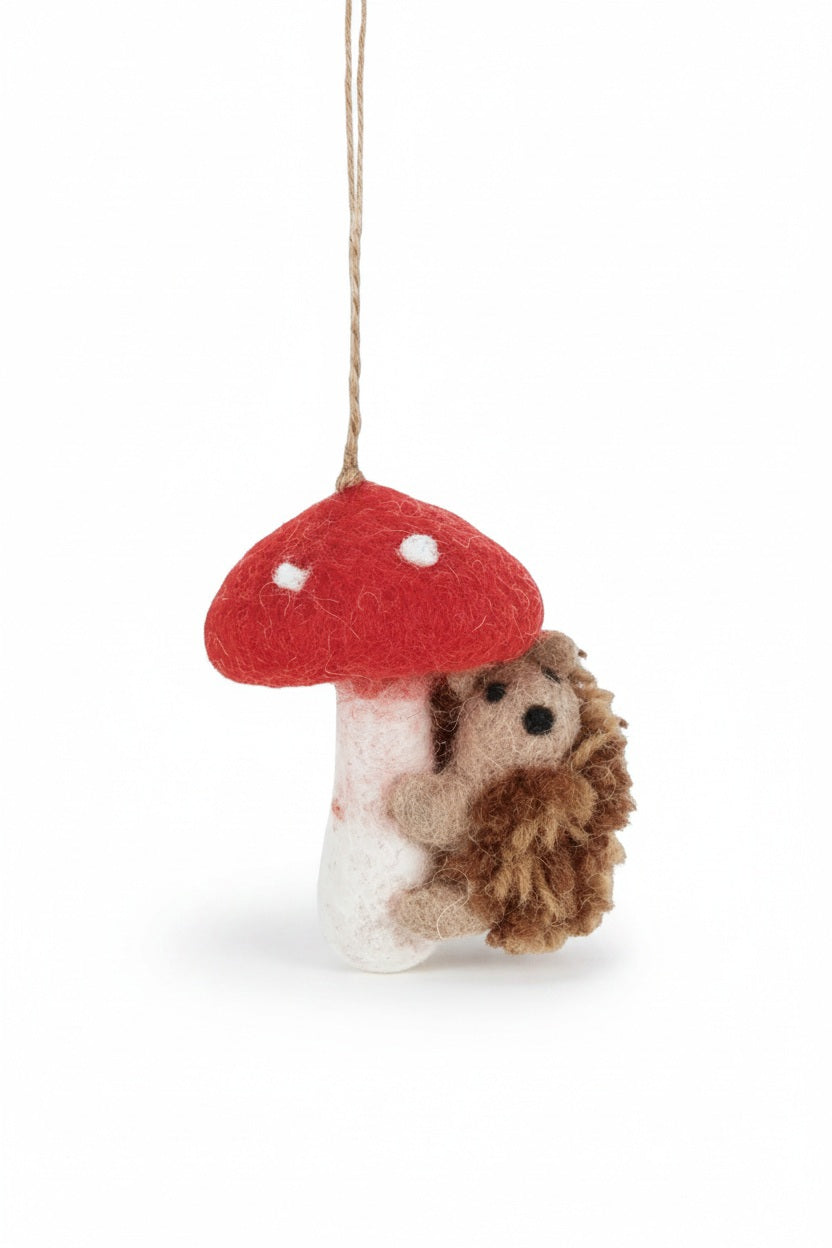 Handmade wool TOADSTOOL HEDGEHOD ORNAMENT featuring a hedgehog hugging a needle felted toadstool with a hanging loop.