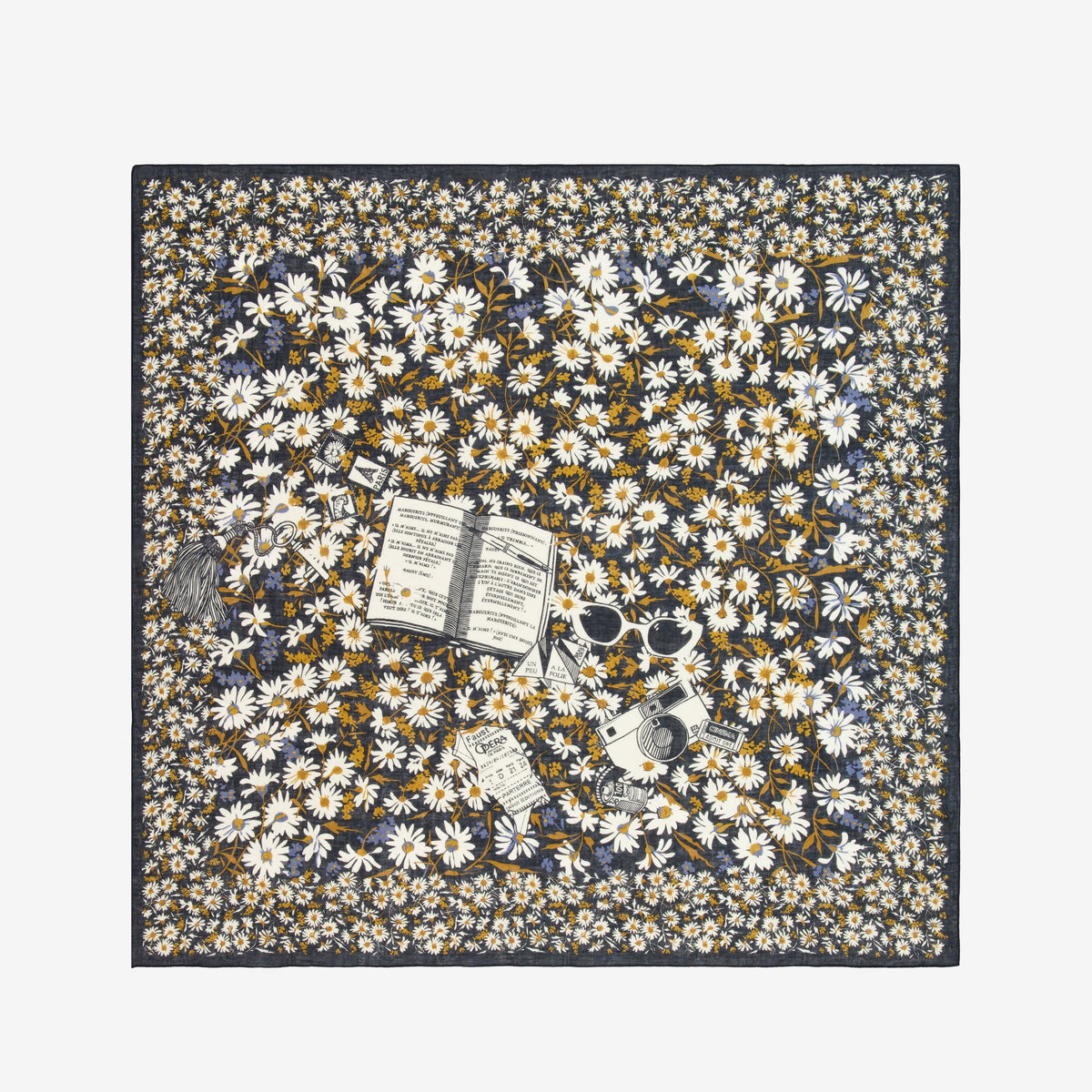 A woman with short hair, in a black sleeveless top and blue pants, stands against a white background. She wears the INOUI EDITIONS FAUST SCARF IN BLACK from INOUI, featuring yellow and white flowers, wrapped around her neck.