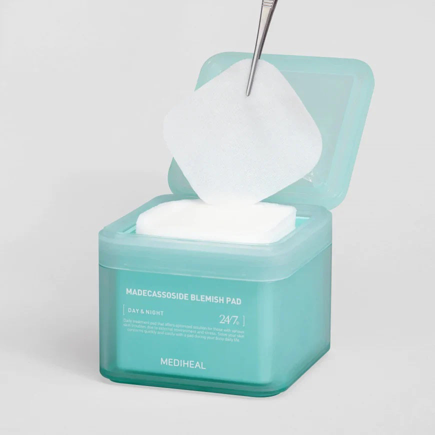 A teal container of &quot;Mediheal - Blemish Pads 100pc&quot; from Exod International, infused with Centella Asiatica for day and night use, highlights its purpose as a daily treatment to provide &quot;24/7&quot; care and address skin issues caused by environmental stress.