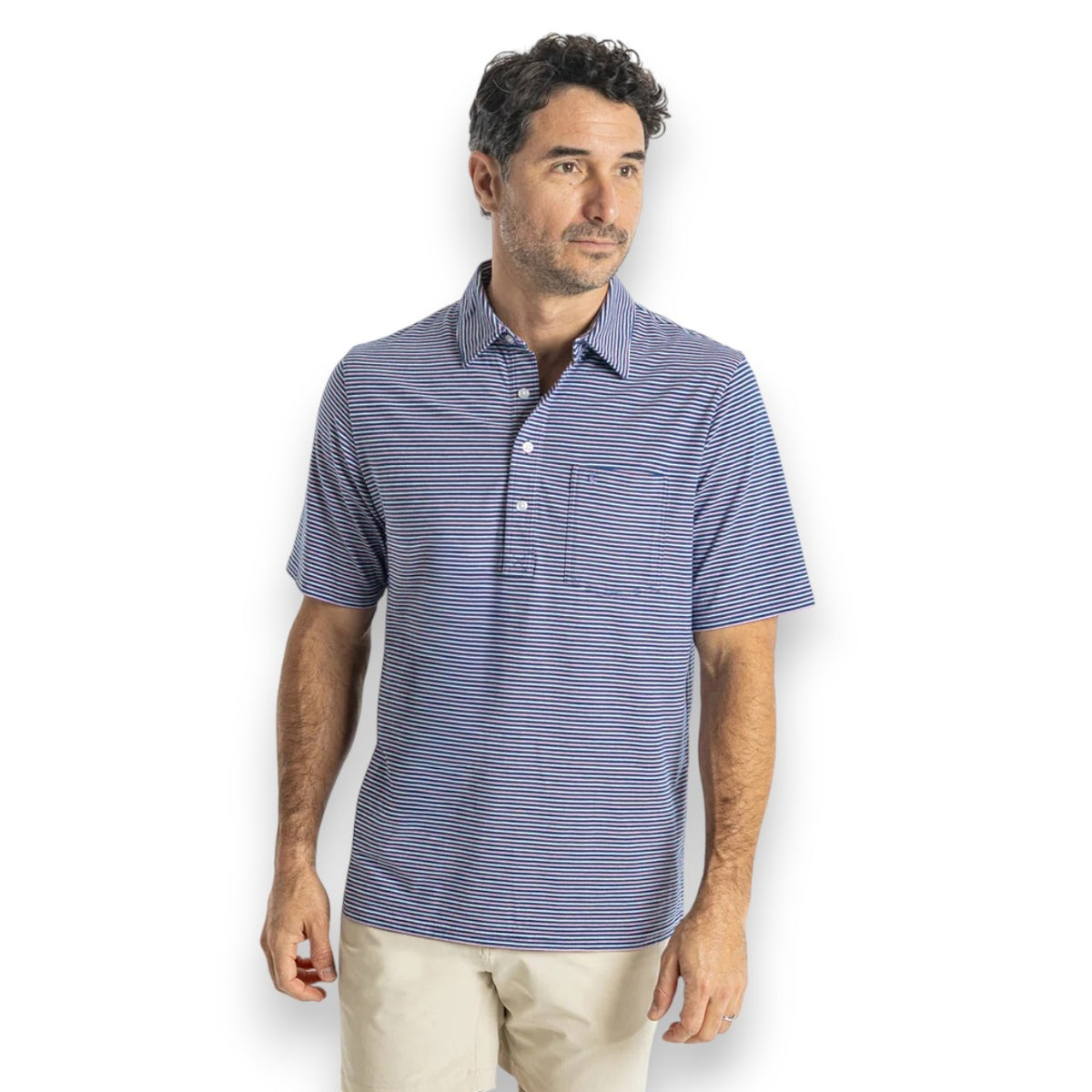 Close-up of a person wearing the CRIQUET Top-Shelf Players Shirt in Stewart Stripe Navy, featuring blue and white stripes, a collar, three buttons, and a small chest pocket. The face is not visible.