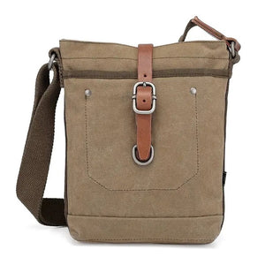The TSD BRAND - FOREST ZIP CROSSBODY BAG IN OLIVE is a military-inspired khaki canvas bag with a front pocket, brown adjustable strap, decorative leather buckle, metal rivets, and textured shoulder strap for style and durability.