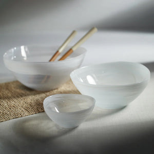 The ZODAX MONTE CARLO ALABASTER GLASS BOWL is a glossy, white, asymmetrical glass bowl measuring 9.75 in x 4.25 in, shown on a white background.