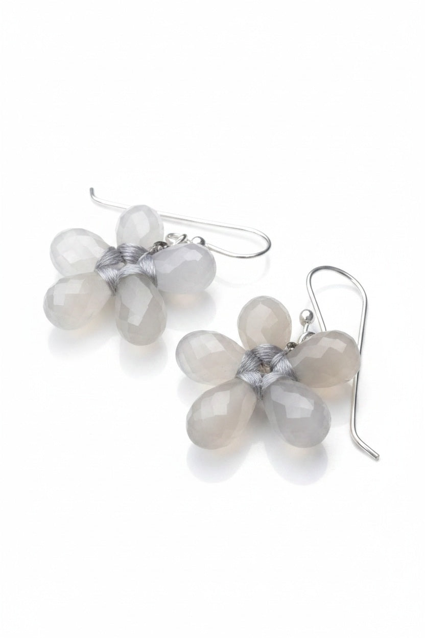 The ANN LIGHTFOOT Faceted Grey Onyx Glower Earrings feature blossom-inspired designs with five translucent, teardrop-shaped grey onyx petals and sterling silver hooks. The image background is plain white.