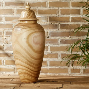 The PAULOWNIA WOOD COVERED TEMPLE JAR - LARGE by TWO'S COMPANY is a tall, light brown jar crafted from paulownia wood, complete with a lid and adorned with natural swirling grain patterns and a smooth, polished finish—an exotic home accent ideal for temple-inspired decor.