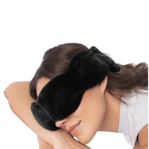 The NODPOD Silk Weighted Sleep Eye Mask in Noir by NODPOD is a dark blue, segmented eye mask featuring a strap-free design and unique four-pad shape. Text highlights its calming effect for stress relief and relaxation, all set against a light background.