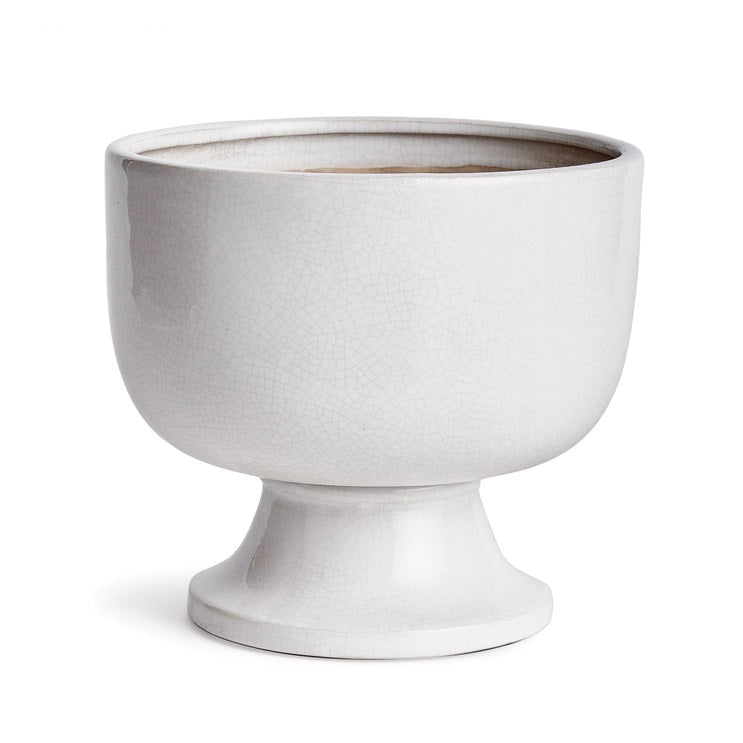 A photograph of the NAPA HOME AND GARDEN - ALBIE FOOTED CACHEPOT, a traditional white ceramic pedestal bowl with a textured, crackled finish. It features a smooth, glossy surface on a wide base, perfect for enhancing any home decor as a centerpiece.