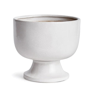 A photograph of the NAPA HOME AND GARDEN - ALBIE FOOTED CACHEPOT, a traditional white ceramic pedestal bowl with a textured, crackled finish. It features a smooth, glossy surface on a wide base, perfect for enhancing any home decor as a centerpiece.