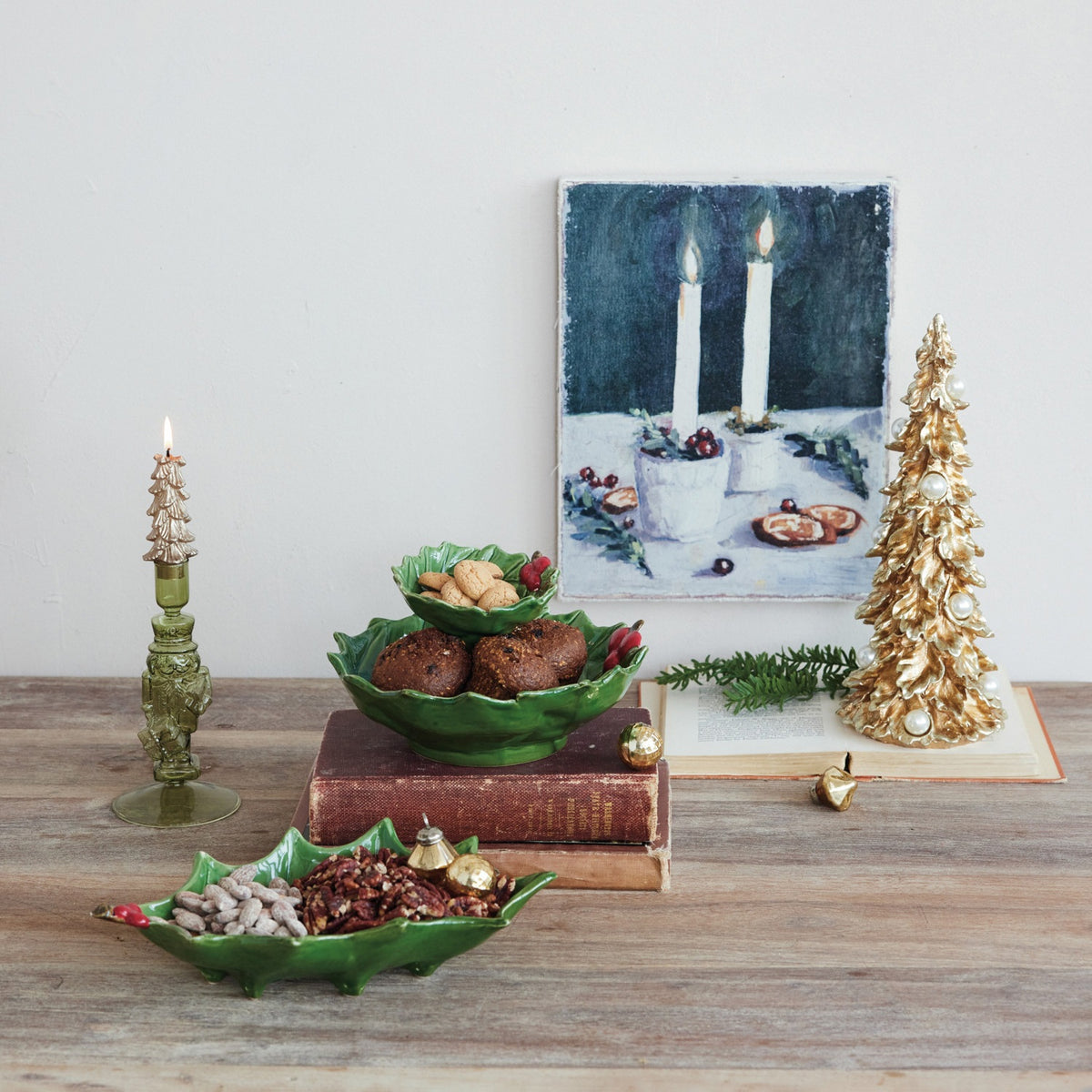 Top and side views of a Creative Coop HAND PAINTED HOLLY LEAF SHAPED FOOTED TRAY WITH BERRIES, showing its holly leaf shape, hand-painted red berries, and short feet.