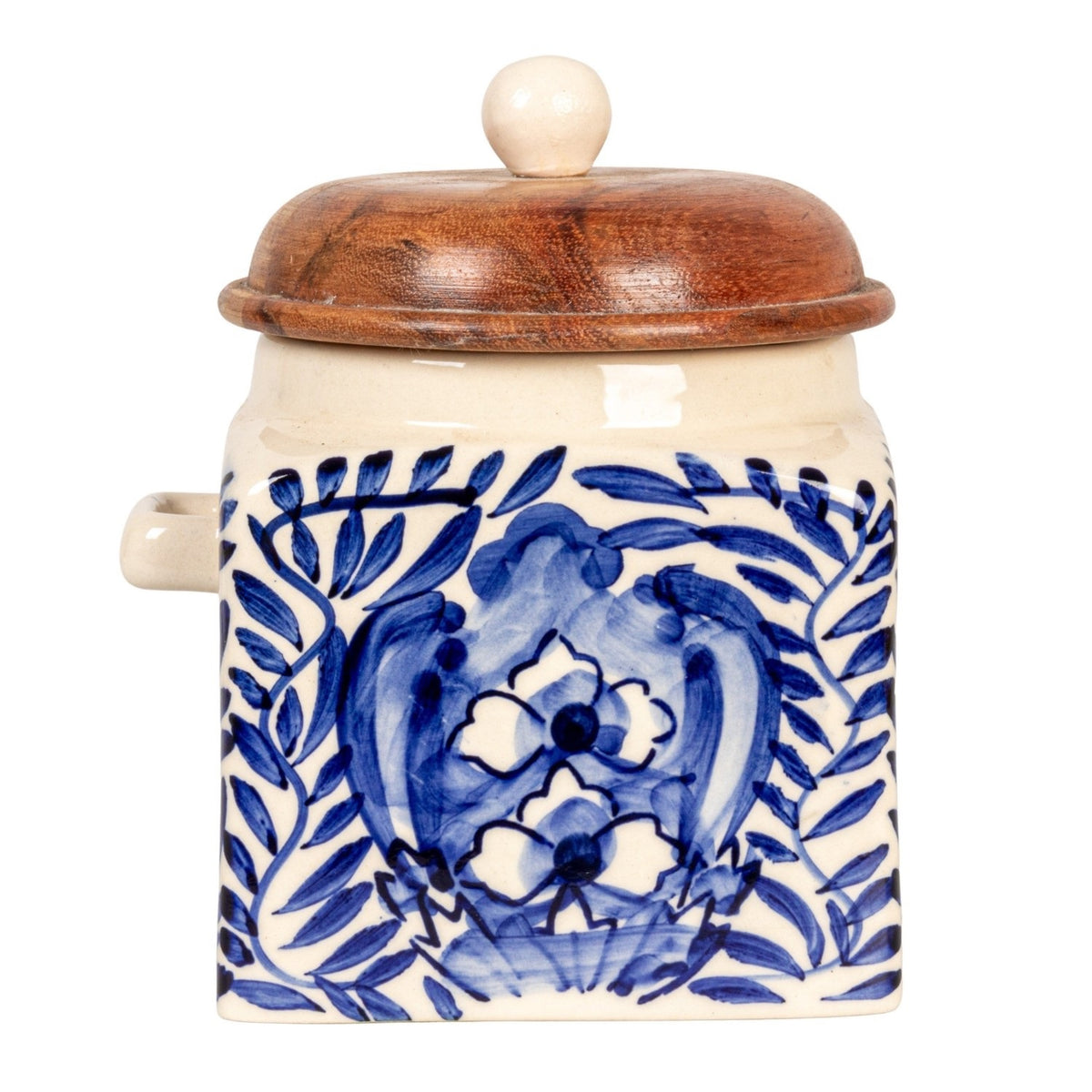 A close-up of the CREATIVE COOP HAND-PAINTED STONEWARE CANISTER WITH LID AND SPOON shows blue floral designs on cream stoneware and an acacia wood lid—an elegant farmhouse kitchen accent.