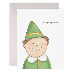 The E. Frances Paper "Smiling Buddy Elf" holiday card features a watercolor elf inspired by the Elf movie with the phrase "smiling is my favorite!" It comes with an envelope.