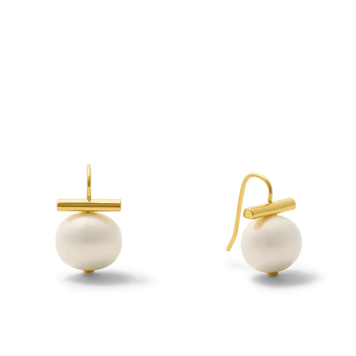 A pair of CC AND CO BY CATHERINE CANINO Medium Pebble Pearl Earrings by CC & CO BY CATHERINE CANINO, crafted in 14 karat gold with large white pearls suspended below horizontal gold bars and finished with handmade ear wires, displayed on a white background.
