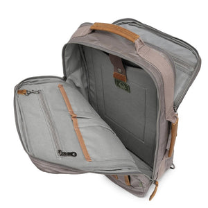 A close-up of the TSD BRAND - MADRONE Coated Canvas Backpack in Grey shows its brown leather accents and an unzipped front pocket with a black wallet partially visible inside.