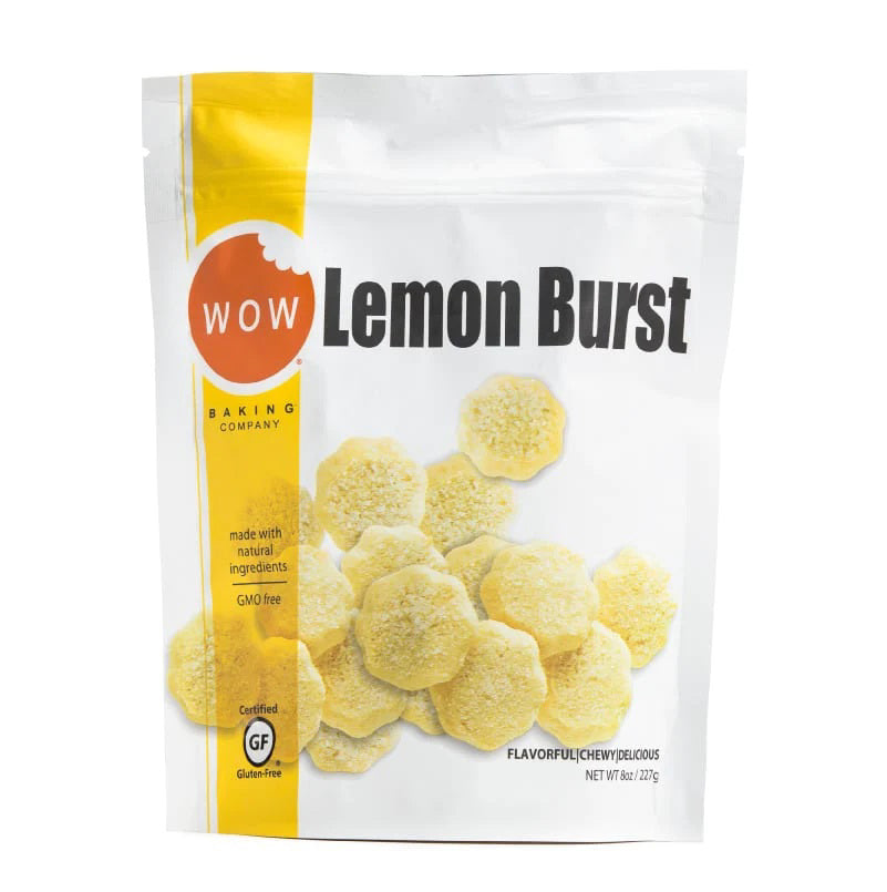 A brightly colored white and yellow packaging bag from WOW BAKING COMPANY showcases their Gluten Free Lemon Burst Cookie Pouch. The front features an image of the gluten free lemon cookies scattered aesthetically. The bag highlights that the product is gluten-free, GMO-free, and made with natural ingredients.