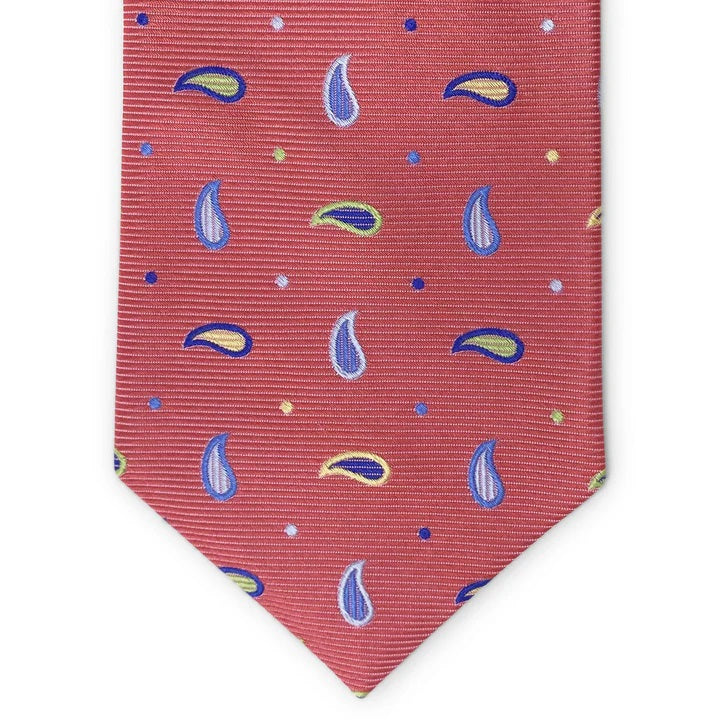 A rolled-up BIRD DOG BAY PETER-BLAIR Bespoke Paisley Soiree Silk Tie in red, featuring blue, yellow, and green paisleys and dots with a subtle diagonal ribbed texture, expertly handmade in New York.