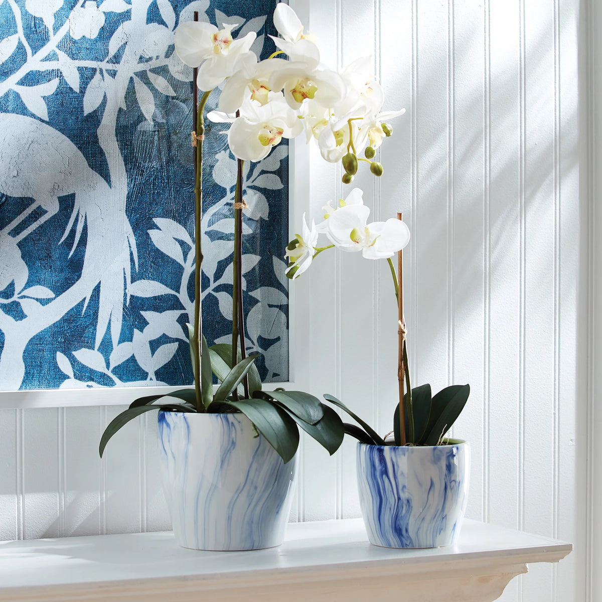 Two glossy marbleized pots with a white and blue pattern sit side by side. The left pot is larger, showcasing the elegance of NAPA HOME AND GARDEN&#39;s collaboration with Barclay Butera, reminiscent of his sophisticated style.