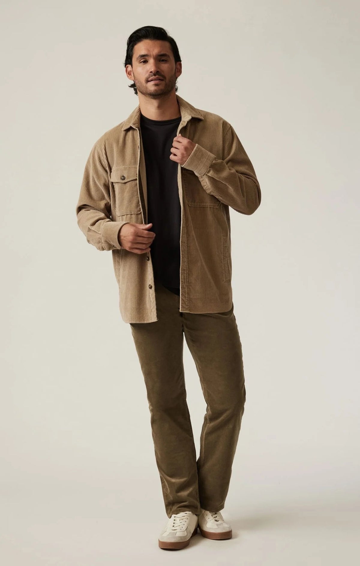 Man wearing 34 HERITAGE - COURAGE STRAIGHT LEG CORDUROY PANTS IN TOBACCO and white sneakers.