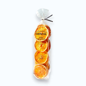 A clear plastic bag of DARDIMANS - CRISPY ORANGE SLICES by DARDIMANS CALIFORNIA CRISPS stands upright on a light surface—vitamin-rich snacks made from premium California oranges.