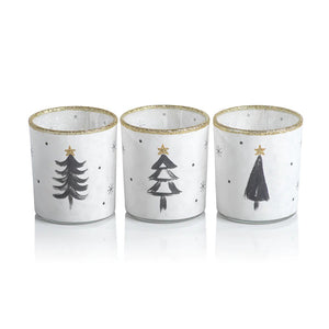 The ZODAX TREE TEALIGHT HOLDER, sold individually, features simple black Christmas tree designs, gold stars, gold glitter rims, and scattered small black dots. Call store for availability.