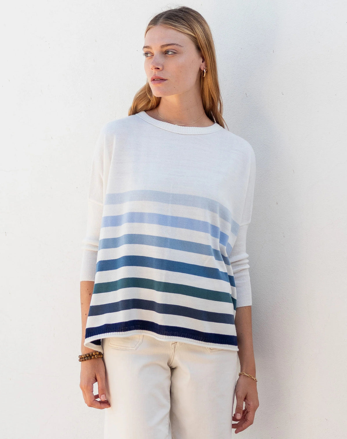 Woman wearing the MERSEA - CATALINA CREWNECK SWEATER, white with two black stripes, paired with denim shorts and a gold necklace—an essential piece from MERSEA for effortless, versatile style.
