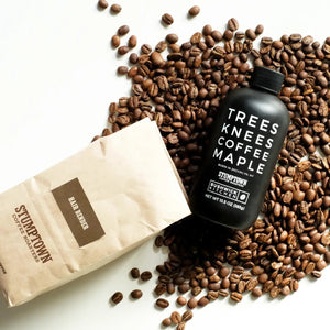 A black bottle labeled “TREES KNEES COFFEE MAPLE” features white text and displays both the Bushwick Kitchen and Stumptown Coffee Roasters logos. With a black cap and 11.5 oz (326g) of gluten-free maple syrup infused with rich coffee flavor, BUSHWICK KITCHEN - ‘TREES KNEES’ COFFEE MAPLE SYRUP makes an excellent addition to any maple syrup gift set.