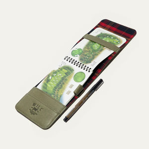 The WILL LEATHER GOODS - GOLF YARDAGE BOOK IN GREEN lies open with a black and brown pen in front, displayed on a plain white background.