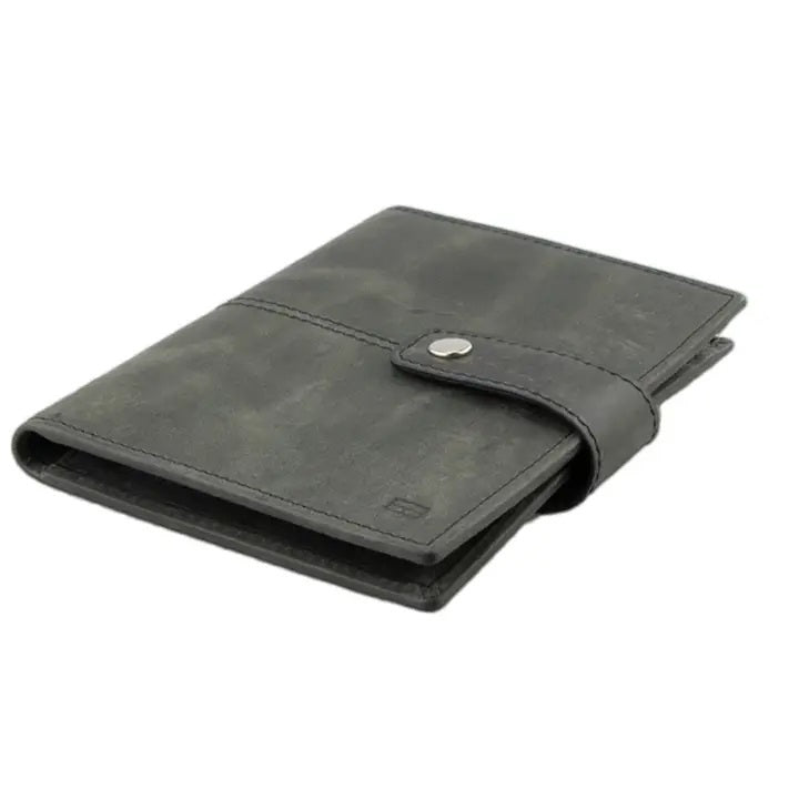 The GARZINI RFID-blocking leather passport holder in black features an AirTag compartment and snap button closure, shown on a white background.