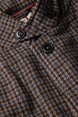 The RELWEN Heritage Trap Blazer in Brown and Blue Check features a brown and black plaid pattern, reminiscent of a classic check blazer, shown from the back with buttoned cuffs and a subtly wrinkled texture, laid flat on a white background.
