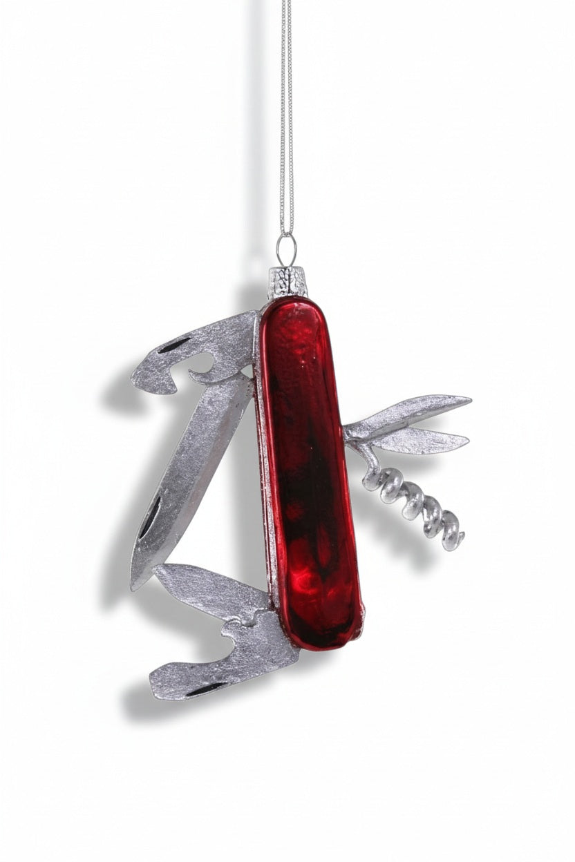 A 3.5-inch GLASS SWISS ARMY KNIFE ORNAMENT by Cody Foster, shaped like a multi-tool pocket knife with a red handle and silver folded blades.