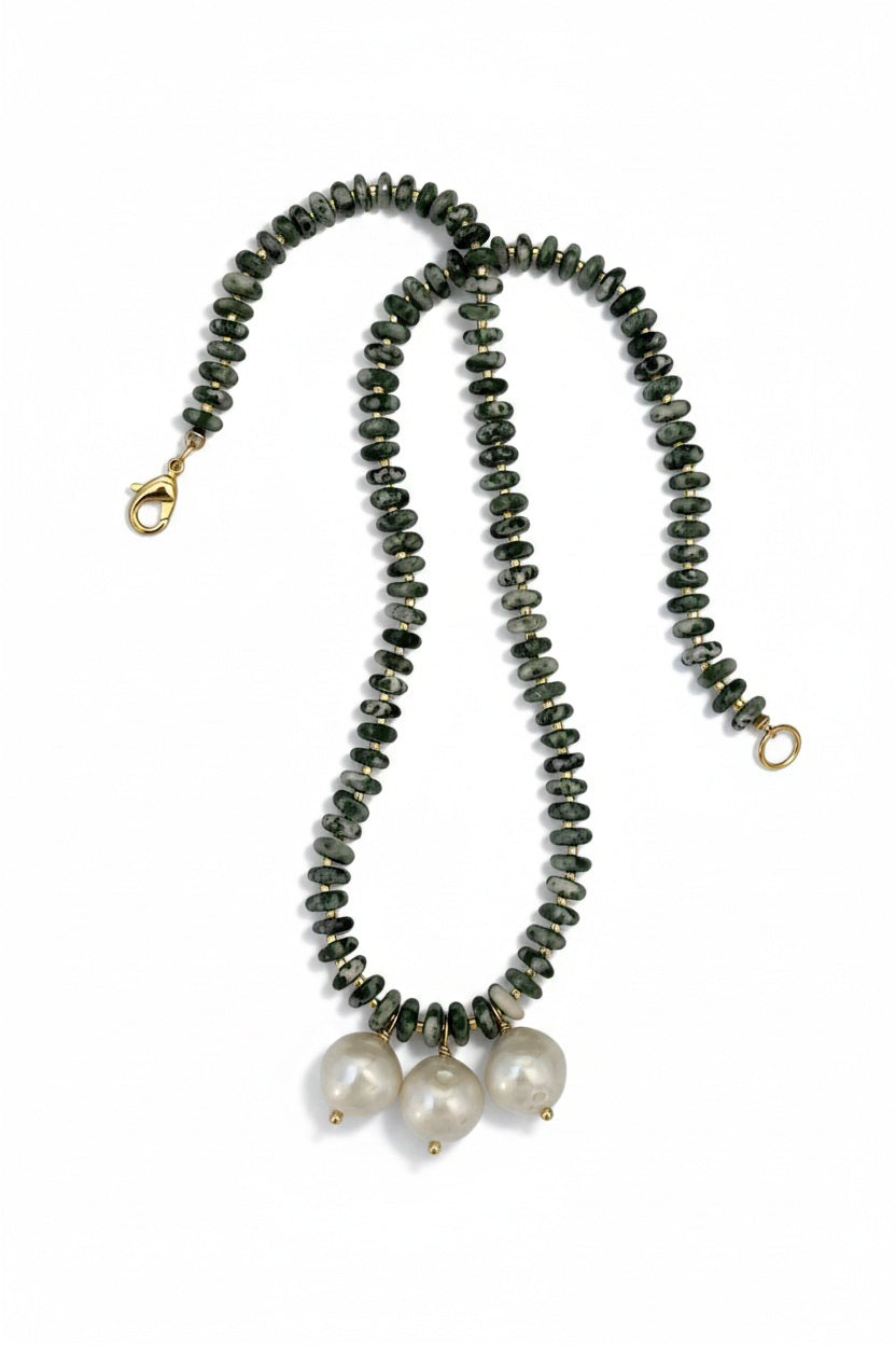 The SANDRINE FRANCE STUDIO - MADELEINE TREE AGATE NECKLACE by SANDRINE FRANCE STUDIO features dark, round Tree Agate beads and three large, white baroque pearls at the center. This handcrafted piece is finished with a gold clasp and closure, elegantly presented against a white background.