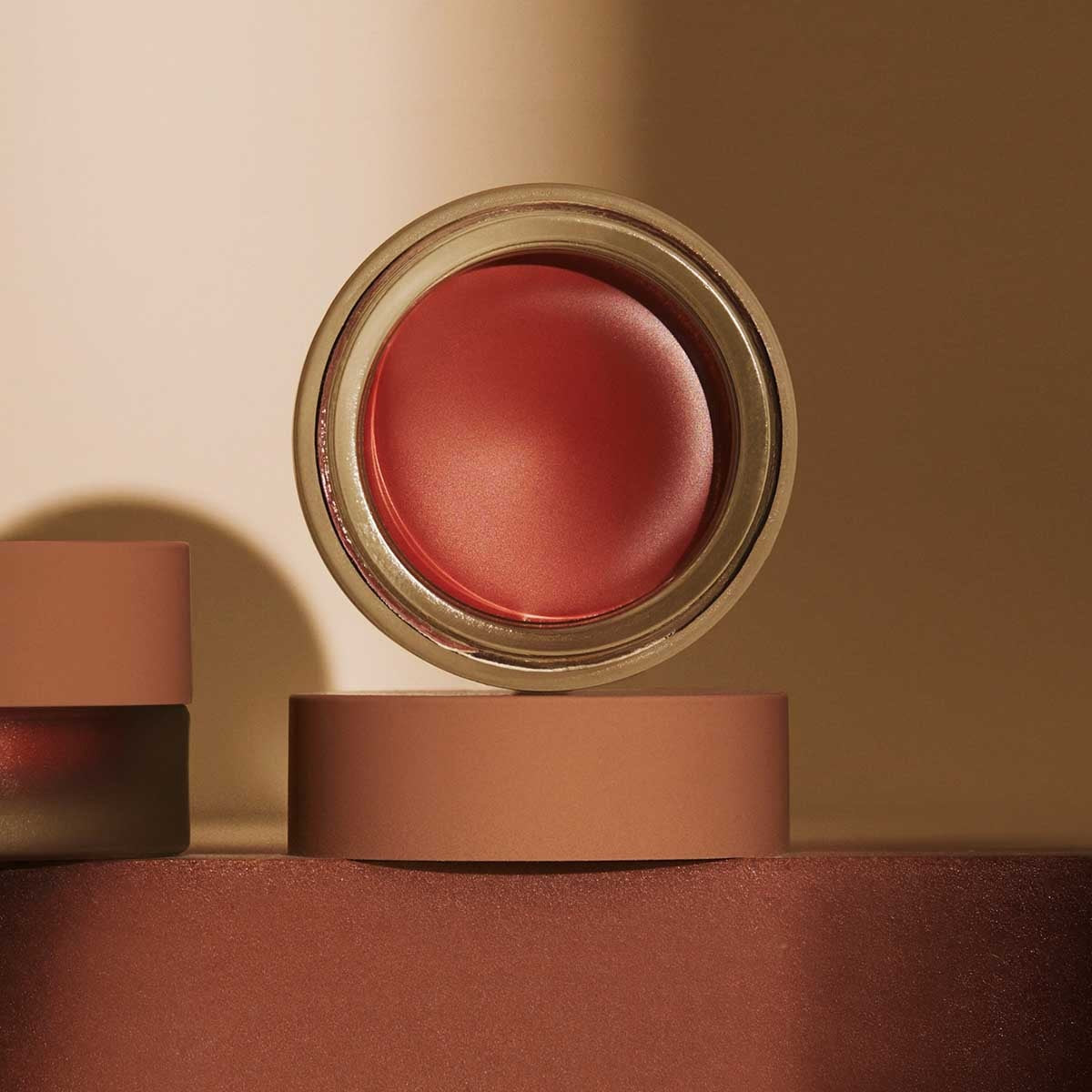 A single swatch of MINORI - CREAM BLUSH in Scarlet sweeps across a white background, revealing its creamy texture and rich pigment—capturing the effortless glow of a natural-looking blush from MINORI.