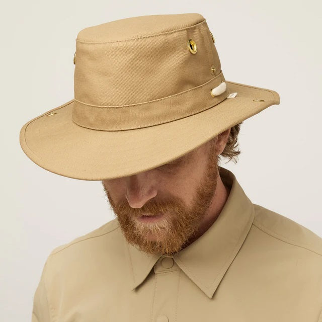 A man with a reddish beard and mustache wears the TILLEY - CLASSIC T3 HAT IN DARK KHAKI and a matching collared shirt, looking at the camera. This TILLEY hat offers UPF 50+ protection and is made in Canada.