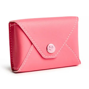A person in a cream sweater holds the E. FRANCES - E. FRANNIE PACK, BUBBLEGUM wallet by E. FRANCES PAPER, pulling out a white card with red hearts—an adorable gift for spreading joy.