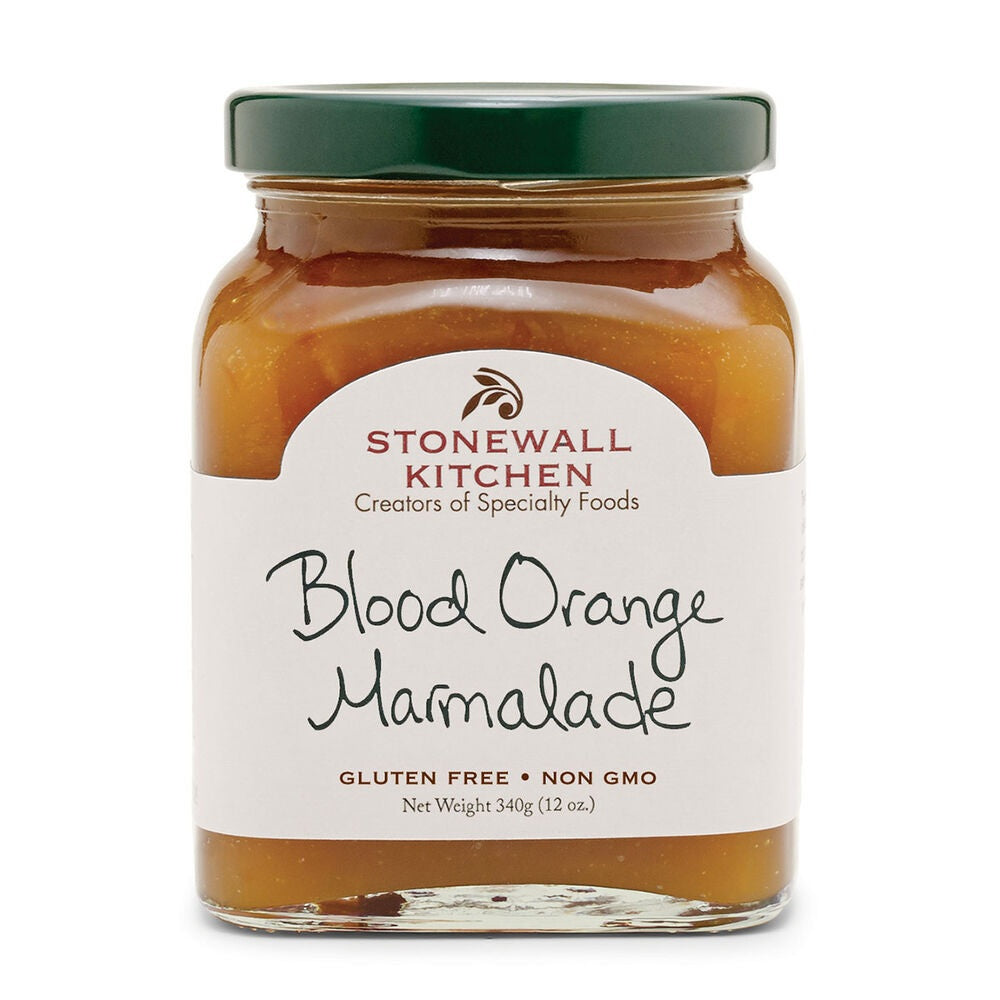 A jar of STONEWALL KITCHEN - BLOOD ORANGE MARMALADE from STONEWALL KITCHEN features a green lid and a white label with handwritten-style text, highlighting details like “Gluten Free” and “Non GMO.” Crafted from ripe blood oranges, this sweet marmalade offers a vibrant, citrusy flavor.