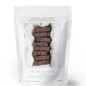 A white pouch labeled "MAISON ZOE FORD - BIG TIME BROWNIE MIX" features a clear window displaying rich, luxurious brownies with chunks inside. The packaging reads "Exceptional Baking Mixes - Meilleure Mélange À Cuisson", "12 Brownies," and has a net weight of 675g. Get ready to bake the best brownies worthy of Top Chef Canada!