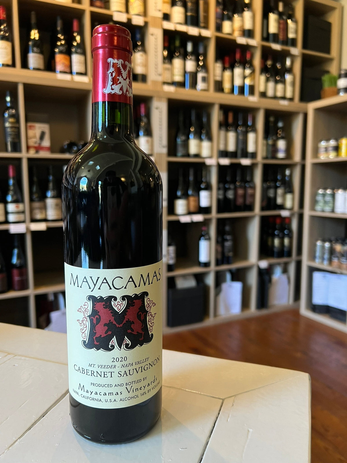 A bottle of MAYACAMAS CABERNET SAUVIGNON 2020 from WINE: KELLOGG SELECTIONS, featuring a red foil top, cream label, and bold red "M"—an outstanding Napa Valley wine.