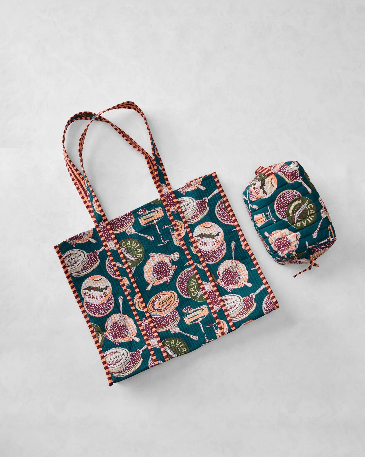 Discover a repeating pattern of caviar tins, open shells filled with caviar, mini forks, and champagne glasses set against a deep green background—an elegant design featured on the PRINTFRESH - CHAMPAGNE & CAVIAR TRAVELER TOTE by PRINTFRESH.