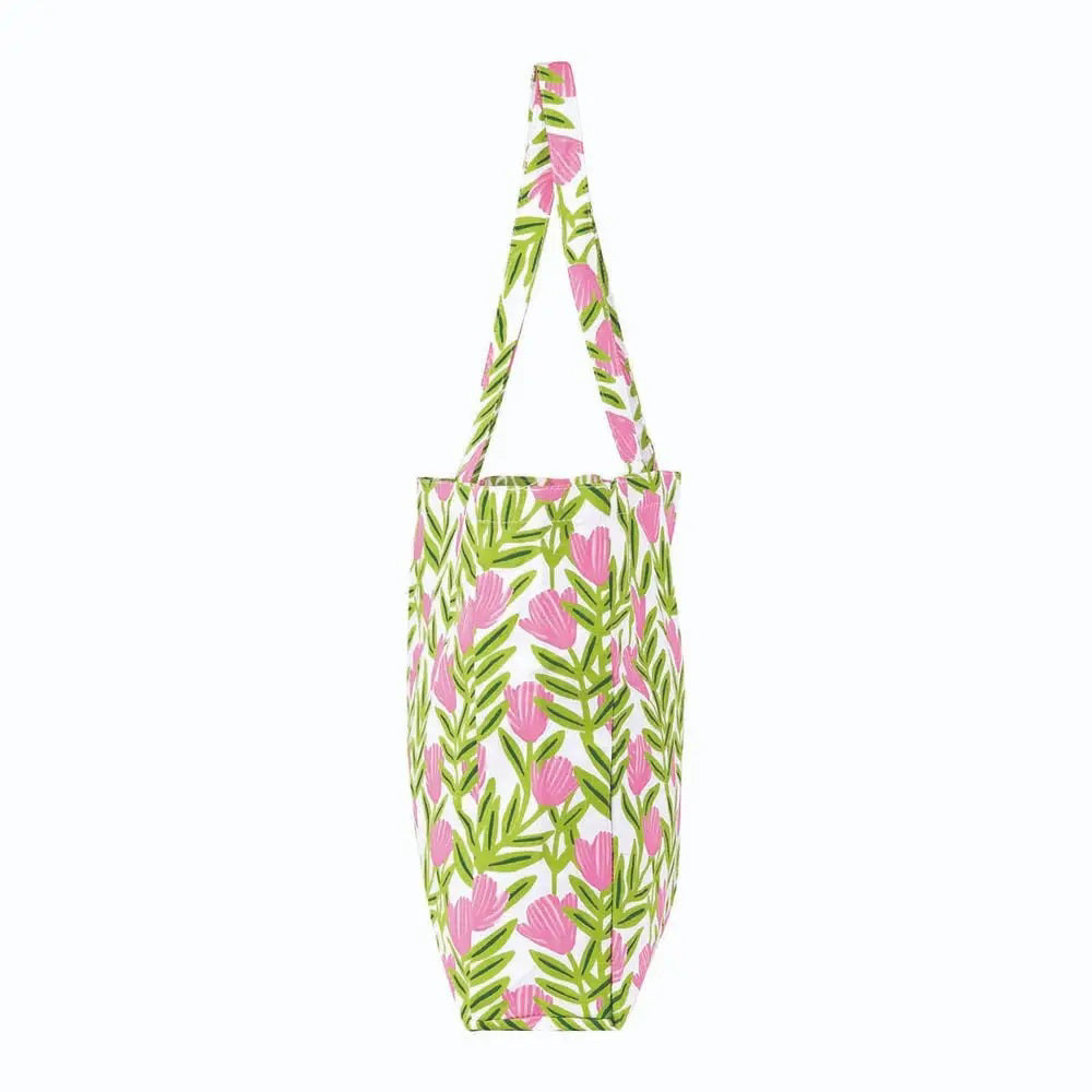 The ROCKFLOWERPAPER Pink Delight Little Shopper Tote Bag features vibrant pink flowers and green leaves on white, with matching floral handles—perfect for stylishly carrying your essentials.