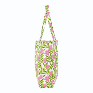 The ROCKFLOWERPAPER Pink Delight Little Shopper Tote Bag features vibrant pink flowers and green leaves on white, with matching floral handles—perfect for stylishly carrying your essentials.