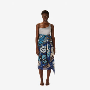 The INOUI EDITIONS - PAPILLON SCARF IN NAVY by INOUI showcases a hand-printed butterfly pattern in blue, white, and tan on navy linen, adding an elegant touch to any outfit.
