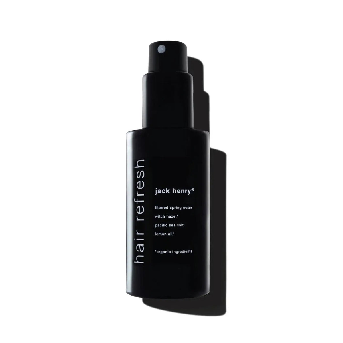 Close-up of a young man with wet, tousled hair styled using JACK HENRY - HAIR REFRESH by JACK HENRY. Water droplets glisten on his skin as he looks down seriously against a plain, light background.