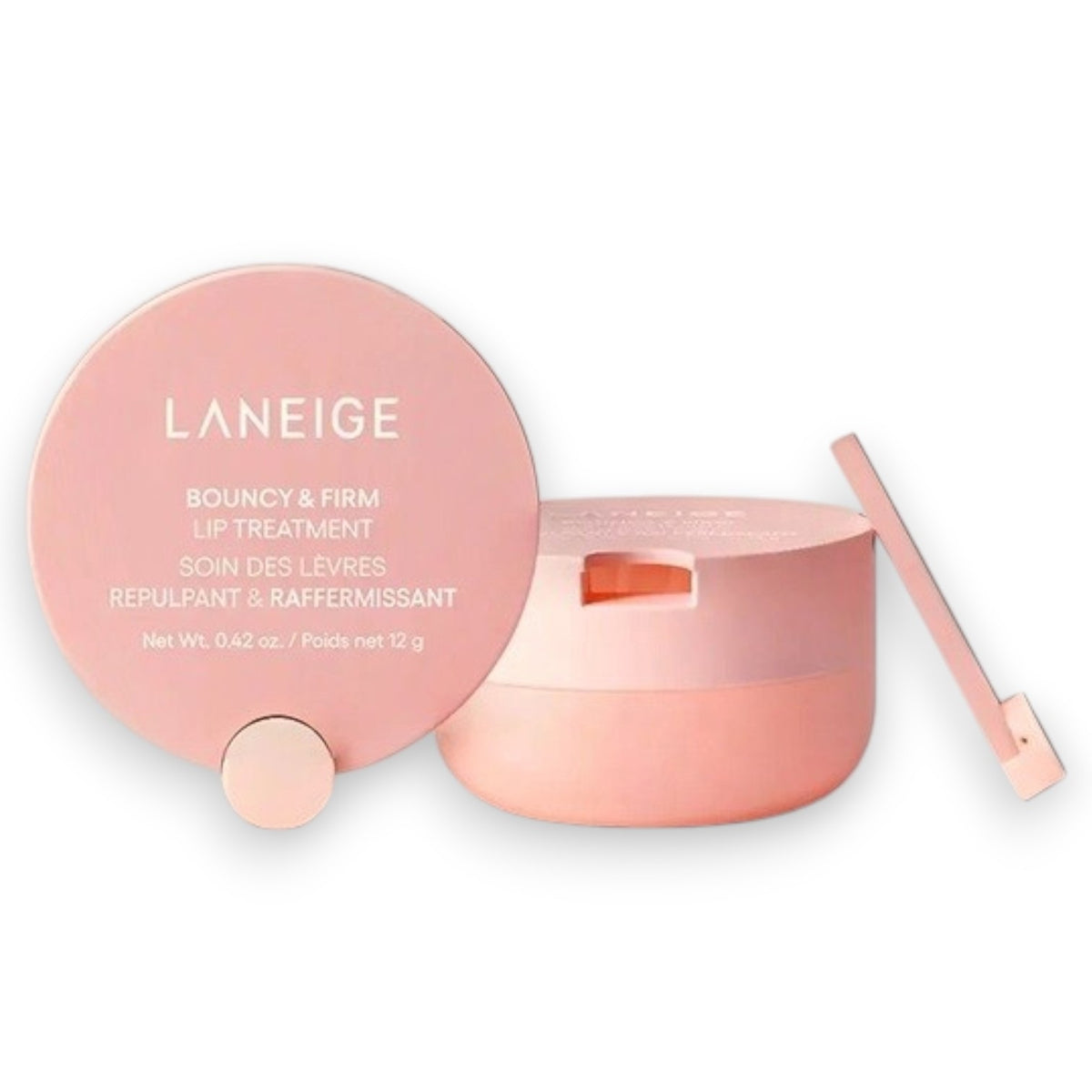 A pink LANEIGE - BOUNCY & FIRM LIP MASK (12g) by KOSMIC KBEAUTY SKINCARE sits open with its lid off, displaying the product inside. Beside the round container lies a small applicator. The label reads “Bouncy & Firm Lip Mask.” Designed to plump and moisturize dry lips overnight, this lip mask leaves your lips soft and healthy-looking.
