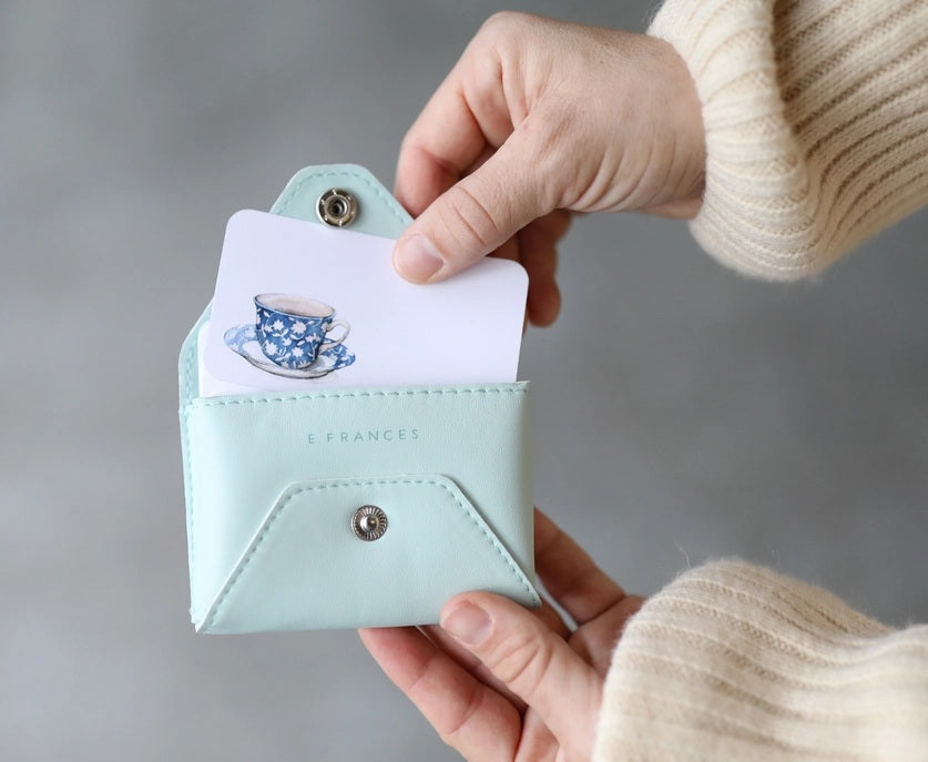 A hand holds the E. FRANCES - E. FRANNIE PACK, SEAGLASS wallet and a "THANKS! You're the best!" Little Note from E. FRANCES PAPER as a joyful gift, with @efrancespaper shown in the corner.