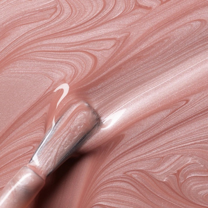 A bottle of MANUCURIST INC’s GREEN™ Nail Polish in the shade “Carnation,” featuring a black cap and pale pink color, with a label that reads “Quick Dry Intense Color.”.