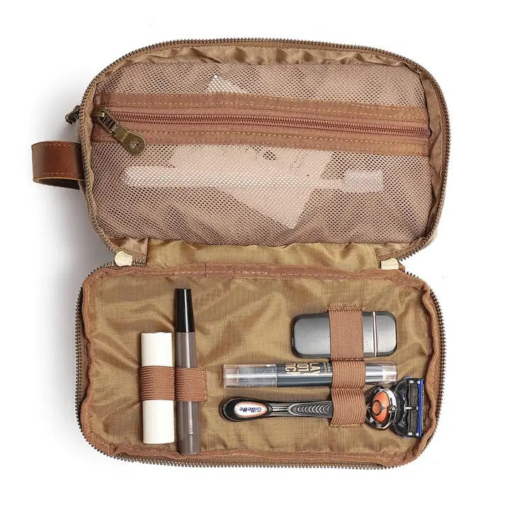 The TSD BRAND Turtle Ridge Toiletry Bag in khaki features leather accents, two zippered compartments, a side handle, and a small logo patch on the front pocket.