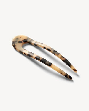 A smooth, black MACHETE - FRENCH HAIR PIN with two prongs, crafted from Italian acetate by MACHETE, rests on a plain white surface.