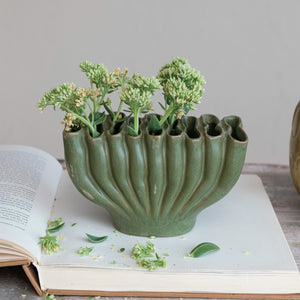 The CREATIVE COOP STONEWARE SCULPTURAL VASE WITH 9 SECTIONS is a matte green vase with a wavy, ridged design and uneven rim, measuring 4.75" tall by 8" wide—an eye-catching modern accent for your décor.