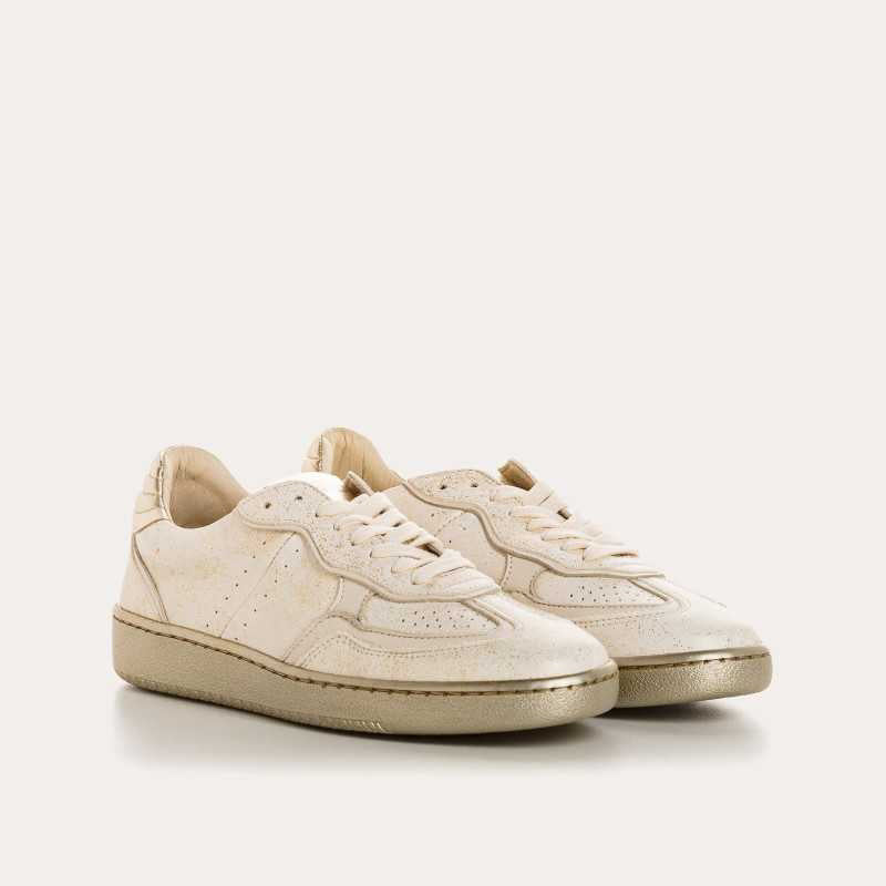 The REQINS ATHENA GLAM sneaker in platinum off white features suede leather, a textured sole, and stitched details, displayed from the side against a plain light background.