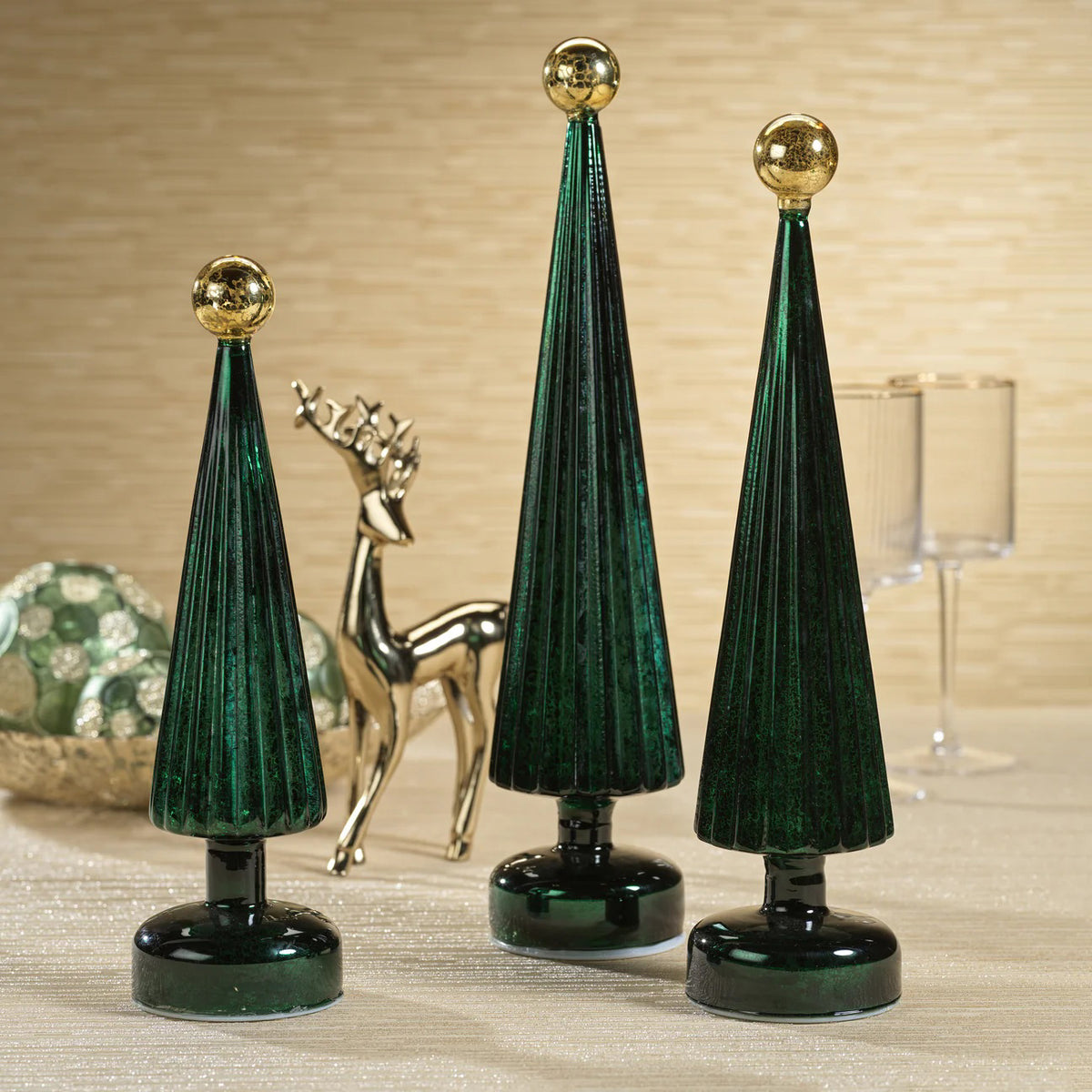 The ZODAX LED TREE WITH GLOBE FINIAL features a dark green, cone-shaped design with vertical ridges and a shiny gold globe top, standing on a round base next to a Glass LED sign, all against a white background.