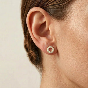 ELLA STEIN - SEALED WITH A KISS STUD EARRINGS by ELLA STEIN, featuring a circular open hoop design with gold plating and two rows of small white gemstones, displayed on a plain white background.